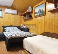 Predaj, chata Byšta - EXKLUZÍVNE HALO REALITY - Izba v Chate s dreveným obložením stien a pohodlnou posteľou.