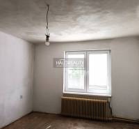 Predaj, rodinný dom Zemplín - EXKLUZÍVNE HALO REALITY - Prázdna miestnosť v rodinnom dome s bielymi stenami, radiátorom a oknom.