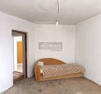 Predaj, rodinný dom Zemplín - EXKLUZÍVNE HALO REALITY - Interiér rodinného domu so starším gaučom a surovou betónovou podlahou.