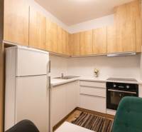 Zariadený 2i byt s lodžiou v rezidencii Pri Mýte - Kuchyňa v 2-izbovom byte s dreveným dekorom a bielymi skrinkami.