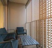 Zariadený 2i byt s lodžiou v rezidencii Pri Mýte - Balkón s dreveným dekorom, posedením a perforovanou stenou v 2-izbovom byte.