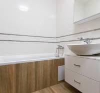 Zariadený 2i byt s lodžiou v rezidencii Pri Mýte - Kúpeľňa v 2-izbovom byte s vaňou, umývadlom a podlahou s dreveným dekorom.