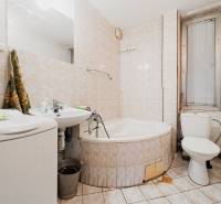 Pozemky s dvoma domami na prestavbu alebo novostavbu - Kúpeľňa s vaňou, umývadlom a práčkou v rodinnom dome.