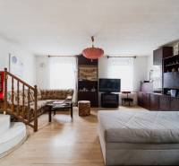 Pozemky s dvoma domami na prestavbu alebo novostavbu - Obývacia izba v rodinnom dome s podlahou s dreveným dekorom a pohodlným posedením.