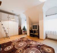 Pozemky s dvoma domami na prestavbu alebo novostavbu - Izba v rodinnom dome s podlahou s dreveným dekorom, televízorom a skriňou.