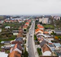 Pozemky s dvoma domami na prestavbu alebo novostavbu - Rodinný dom na Partizánskej ulici v Bánovciach nad Bebravou, lemovaný ďalšími domami.