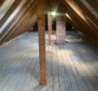 RODINNÝ DOM/CHALUPA VHODNÝ NA DOKONČENIE REKONŠTRUKCIE, ZLIECHOV - Podkrovie v chate s drevenými trámami a tehlovým komínom, podlaha s dreveným dekorom.