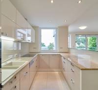 Prenájom exluzívneho 3 izbového apartmánu v Diplomat Parku. - Kuchyňa v 3-izbovom byte s veľkým oknom, bielymi skrinkami a lesklou pracovnou doskou.