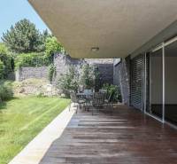 Prenájom exluzívneho 3 izbového apartmánu v Diplomat Parku. - Terasa s podlahou s dreveným dekorom, záhradným sedením a zeleňou pri 3-izbovom byte.