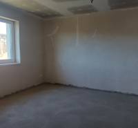 PREDAJ/ Kompletne zrekonštruovaný rodinný dom v Rožňave - Prázdna izba s oknom v rodinnom dome a s nerovnou stenou.