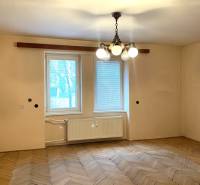 REZERVOVANÉ - Veľký 2-izbový byt s loggiou v centre Martina - Izba v 2-izbovom byte s podlahou s dreveným dekorom a visiacim lustrom.