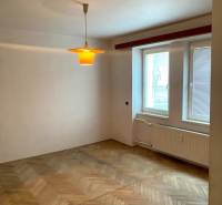 REZERVOVANÉ - Veľký 2-izbový byt s loggiou v centre Martina - Izba v 2-izbovom byte s podlahou s dreveným dekorom a oknom so žalúziami.