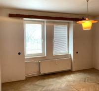 REZERVOVANÉ - Veľký 2-izbový byt s loggiou v centre Martina - Izba so svetlou podlahou s dreveným dekorom, radiátorom a osvetlením v 2-izbovom byte.