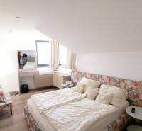 NADŠTANDARDNÝ 5 izbový dom Jánošíkova / Piešťany - Na ulici Jánošíkova v rodinnom dome je útulná spálňa s posteľou a dekoratívnymi záclonami.