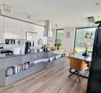 NADŠTANDARDNÝ 5 izbový dom Jánošíkova / Piešťany - Kuchyňa v rodinnom dome s podlahou s dreveným dekorom, jedálenský stôl, množstvo svetla.