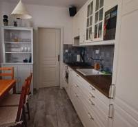 Na predaj 3izbový byt Tranovského , Dúbravka - Kuchyňa v 3-izbovom byte s dreveným stolom, skriňou a rastlinami.