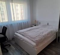 Na predaj 3izbový byt Tranovského , Dúbravka - Spálňa v 3-izbovom byte s posteľou, pracovným stolom a podlahou s dreveným dekorom.