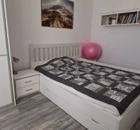 Na predaj 3izbový byt Tranovského , Dúbravka - Spálňa v 3-izbovom byte so šatníkom, posteľou, knihami a podlahou s dreveným dekorom.