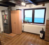 Na predaj 2 izbový rodinný dom, Dolné Orešany! - Kuchyňa v rodinnom dome s podlahou s dreveným dekorom, stolom a chladničkou.