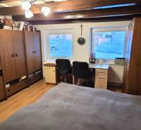 Na predaj 2 izbový rodinný dom, Dolné Orešany! - Izba v rodinnom dome s dreveným dekorom, pracovným stolom a úložnými skrinkami.