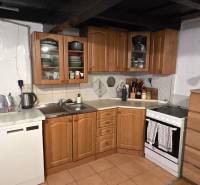 Na predaj 2 izbový rodinný dom, Dolné Orešany! - Kuchyňa v rodinnom dome s drevenými skrinkami, spotrebičmi a bielou stenou.