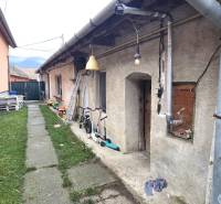 Na predaj 2 izbový rodinný dom, Dolné Orešany! - Exteriér rodinného domu v Dolných Orešanoch s chodníkom, detskými hračkami a zeleňou.