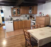 Na predaj 2 izbový rodinný dom, Dolné Orešany! - Kuchyňa s dreveným nábytkom a podlahou s dreveným dekorom v rodinnom dome.
