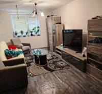 Rodinný dom na veľkorysom pozemku v Drahňove. - Obývacia izba v rodinnom dome s pohovkami a TV, podlaha s dreveným dekorom.