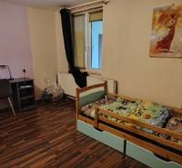 Rodinný dom na veľkorysom pozemku v Drahňove. - Detská izba v rodinnom dome s podlahou s dreveným dekorom a pracovným kútom.