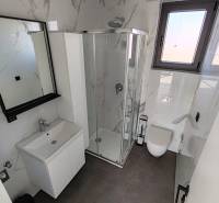 CHORVÁTSKO - Apartmány na ostrove VIR, Zadar - Kúpeľňa v 3-izbovom byte s bielym nábytkom a sprchovým kútom.