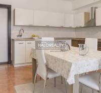 Predaj, rodinný dom Beša - Kuchyňa v rodinnom dome s bielou linkou a jedálenským stolom so štyrmi stoličkami.