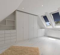 Exkluzívna honosná kúria | 3 ha pozemok | Dunakiliti - HU - Biely interiér so šikmým stropom, skriňou a podlahou s dreveným dekorom.