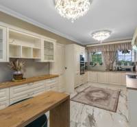 Exkluzívna honosná kúria | 3 ha pozemok | Dunakiliti - HU - Elegantná kuchyňa so svietidlami, drevenými dekoráciami a podlahou s dreveným dekorom.