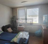 Predaj, jednoizbový byt Žiar nad Hronom, Novomeského - Izba v 1-izbovom byte s posteľou, kreslom, televízorom a veľkým oknom.