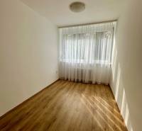 Prenájom 3 izbového bezbariérového bytu, Vetvová ulica, Bratislava - Izba s podlahou s dreveným dekorom v 3-izbovom byte, záclony na okne.