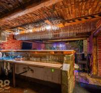 Exkluzívne: Predaj budovy v centre mesta Poprad - Kamenný bar s tehlovými stenami a podlahou s dreveným dekorom v budove.