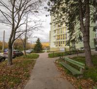 Veľkorysý, príjemný 3(4) izb. byt, 105m2, lodžia, terasa, parkovanie - Exteriér bytovky na Bakošovej ulici s chodníkom a zaparkovanými autami v Bratislave - Lamači.