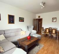 3-izbový zariadený byt, 78 m2, zasklenná loggia, Považská ul., Nitra - Obývačka v 3-izbovom byte s rohovou sedačkou a podlahou s dreveným dekorom.