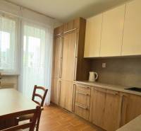 3-izbový zariadený byt, 78 m2, zasklenná loggia, Považská ul., Nitra - Kuchyňa v 3-izbovom byte s dreveným dekorom a svetlým nábytkom, elegantné kvety na stole.