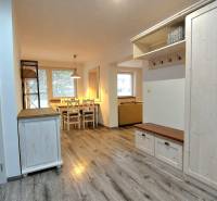 Predaj 3-izb bytu 75 m2 + garáž 18 m2, Trenčín - Pred poľom - Interiér 3-izbového bytu s podlahou s dreveným dekorom a jedálenským stolom.