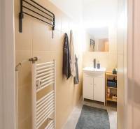 Svetlý, jedinečný 2i byt 62m2, po rekonštrukcií, s pivnicou   - Kúpeľňa v 3-izbovom byte so svetlými obkladačkami, umývadlom a rebríkovým radiátorom.