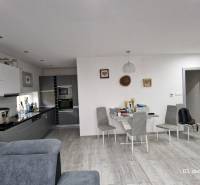 Nový rodinný dom, 7 minút od centra Košíc v tichej uličke pod lesom - Interiér rodinného domu s kuchyňou, jedálenským stolom a podlahou s dreveným dekorom.