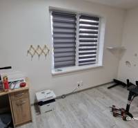 Nový rodinný dom, 7 minút od centra Košíc v tichej uličke pod lesom - Izba v rodinnom dome s podlahou s dreveným dekorom, posilňovacou lavicou a stolíkom.