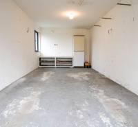 RODINNÝ DOM s garážou na PREDAJ - Dubnica nad Váhom - až 758m²  - Garáž v rodinnom dome s betónovou podlahou a bielymi stenami.