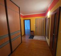 Na predaj priestranný 4-izbový byt 87 m2, Považská Bystrica - Chodba v 4-izbovom byte s podlahou s dreveným dekorom a zabudovanými skriňami.