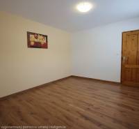 Na predaj priestranný 4-izbový byt 87 m2, Považská Bystrica - Izba s podlahou s dreveným dekorom, obrazom na stene a drevenými dverami.