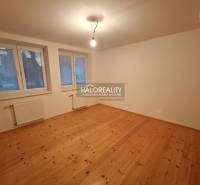 Predaj, rodinný dom Zeleneč - Izba rodinného domu s podlahou s dreveným dekorom, veľkými oknami a radiátormi.