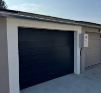 PREDAJ zrekonštruovaná garáž na ulici Slnečná - KOMÁRNO - Brána modernej garáže na Slnečnej ulici v Komárne, vybavená elektrickým ovládaním.