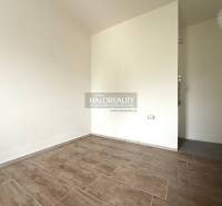 Predaj, rodinný dom Chynorany - Prázdna miestnosť s podlahou s dreveným dekorom v rodinnom dome.