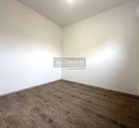 Predaj, rodinný dom Chynorany - Izba s podlahou s dreveným dekorom v rodinnom dome, svetlé steny, radiátor.